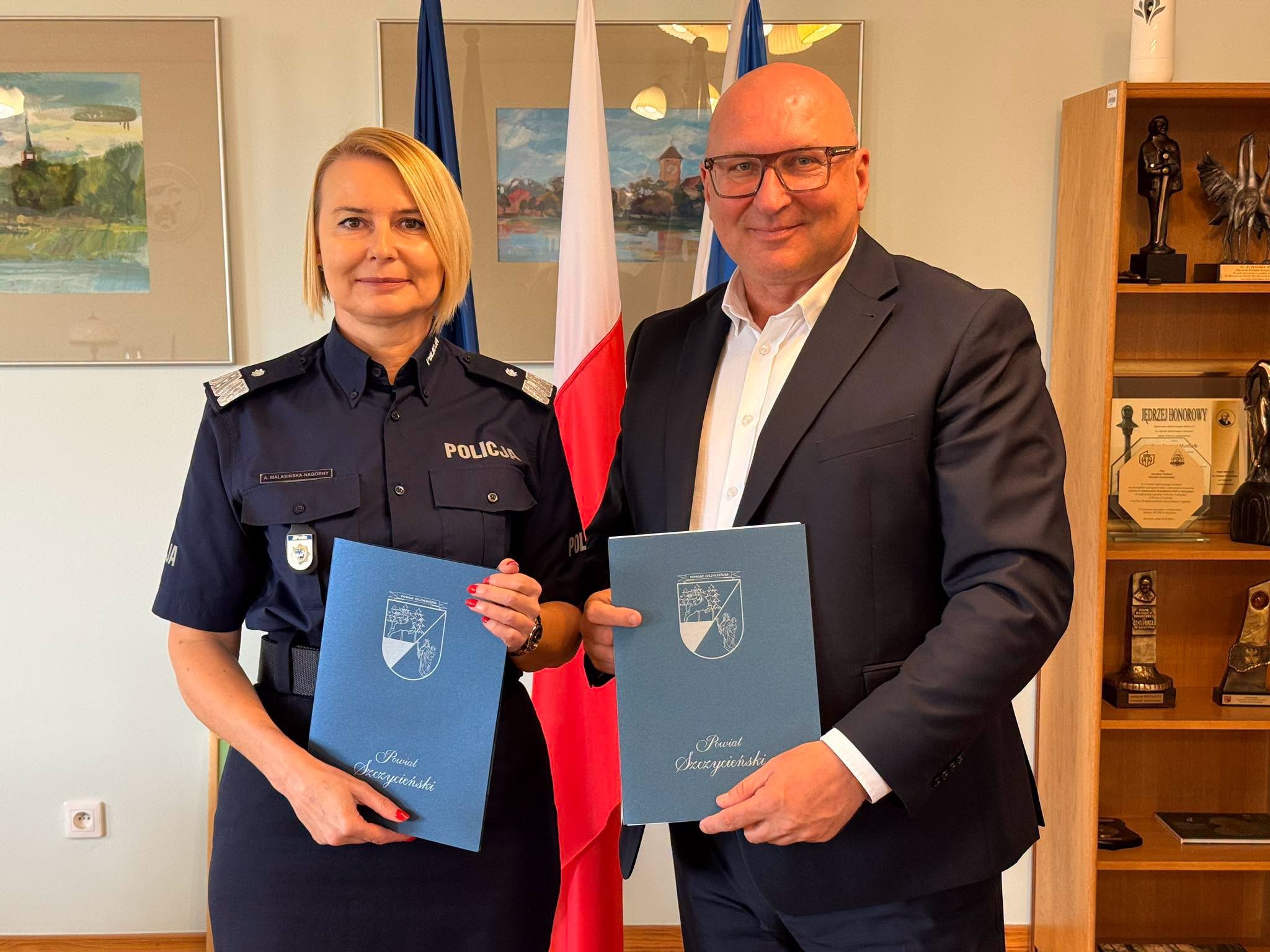 Starosta Szczycieński oraz Komendant-Rektor Akademii Policji w Szczytnie trzymają w rękach podpisaną umowę.