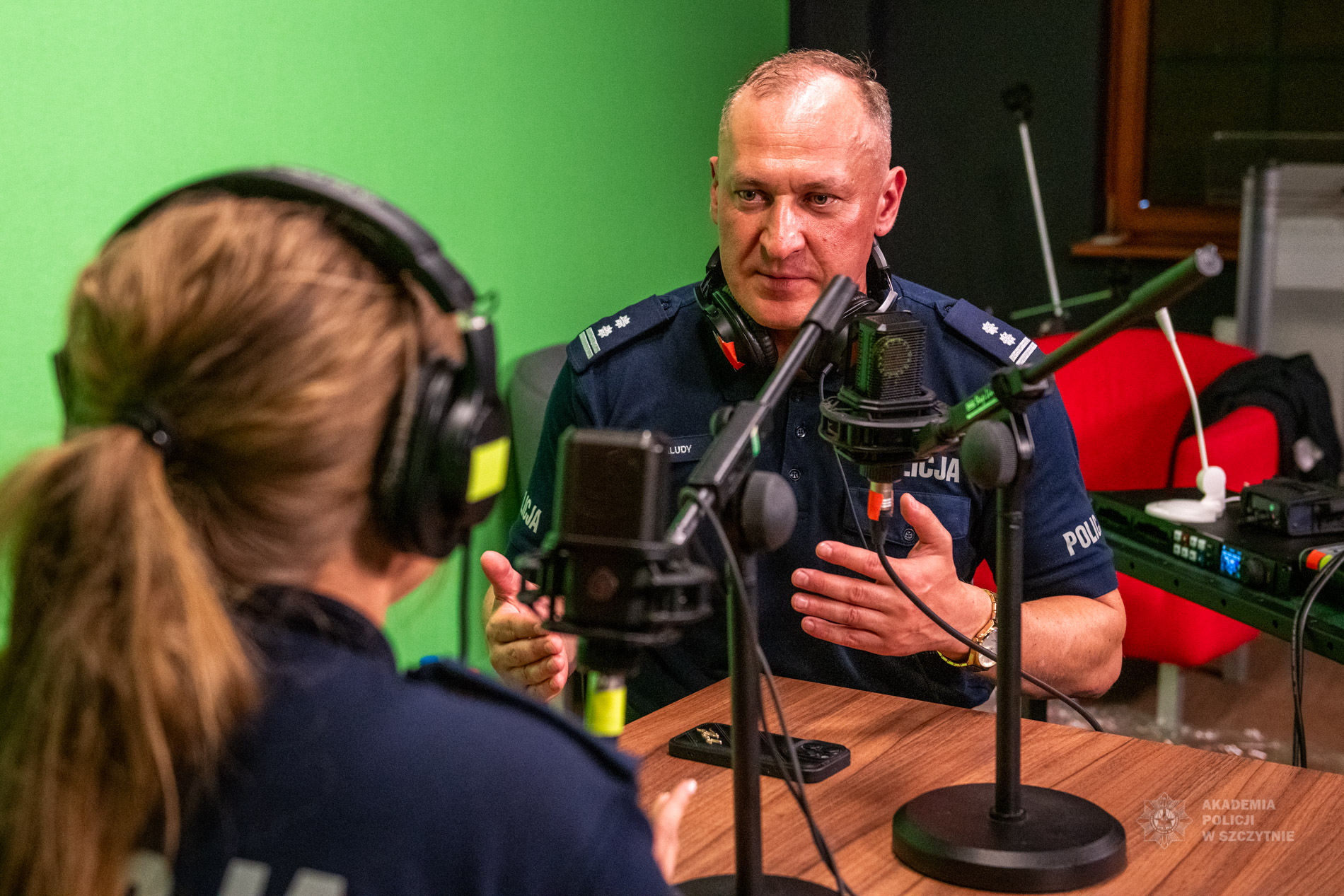 Prowadzący szkolenie młodszy inspektor Marcin Maludy przeprowadza wywiad z uczestniczką szkolenia w studiu nagrań Akademii Policji w Szczytnie.